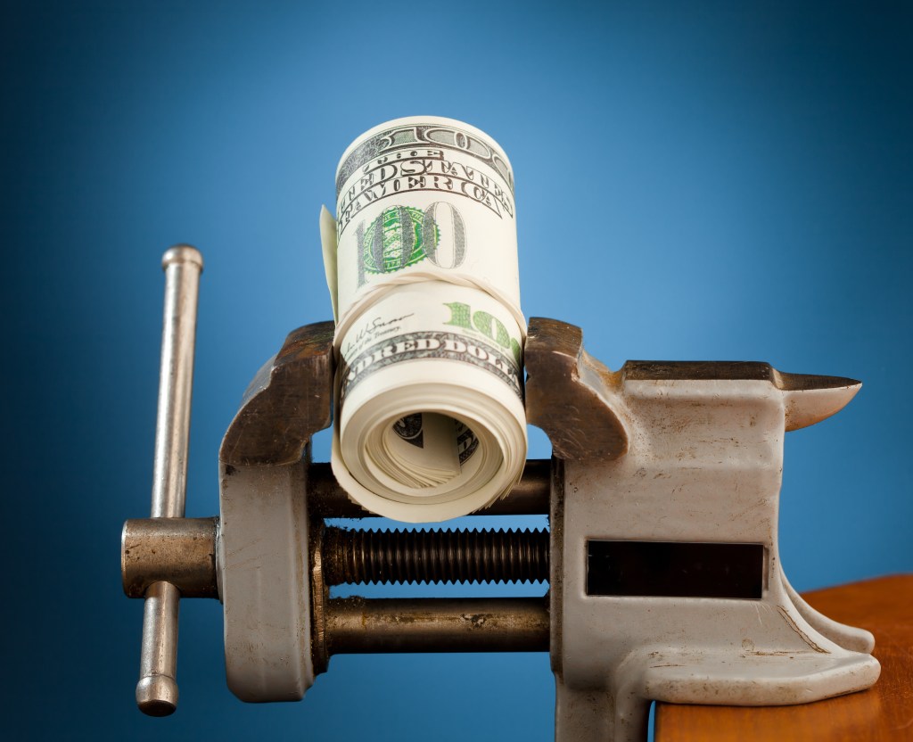 making money concept - money in the vice tool