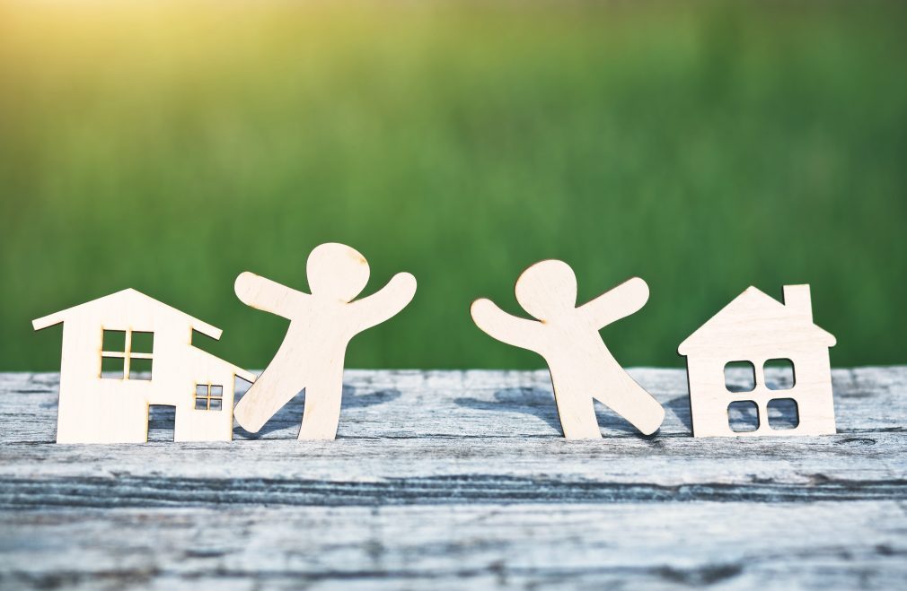 little wooden men in houses. Symbol of neighborhood, friendship, teamwork and sweet home concept