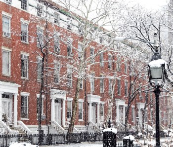 Snow covered winter street scene with old buildings along Washington Square Park in Manhattan New York City NYC
