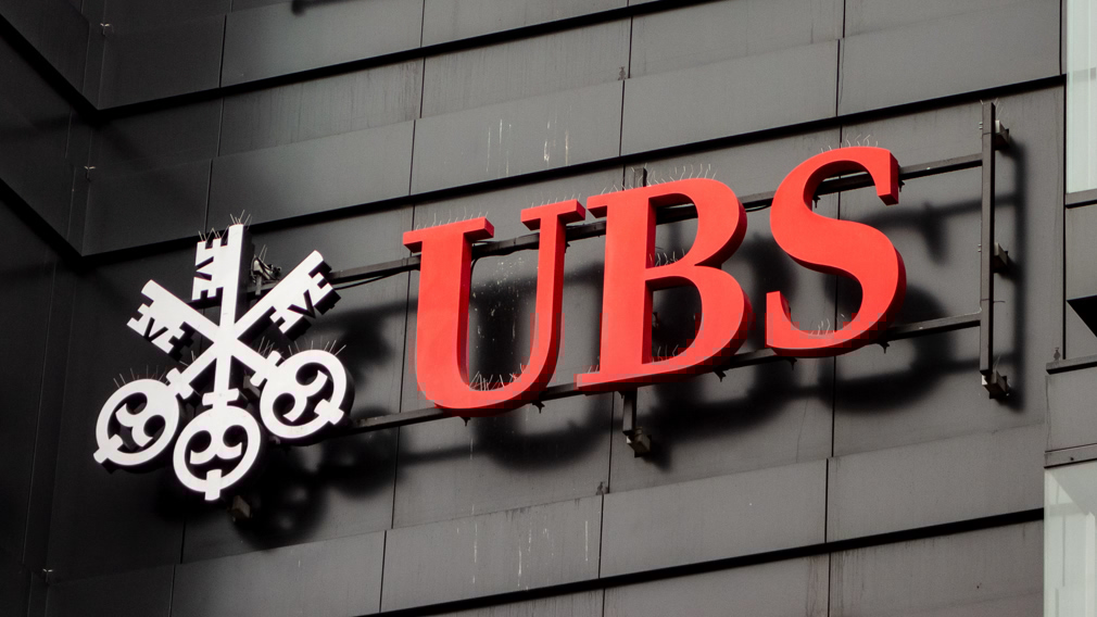 The logo of a Swiss bank UBS on a black wall of building