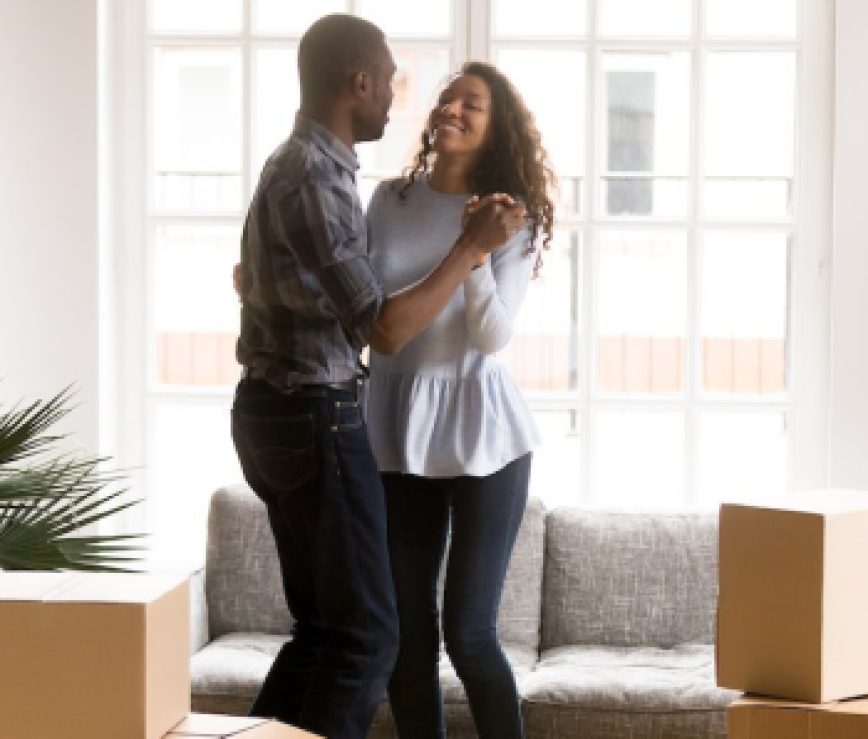 Happy African American couple dancing after moving
