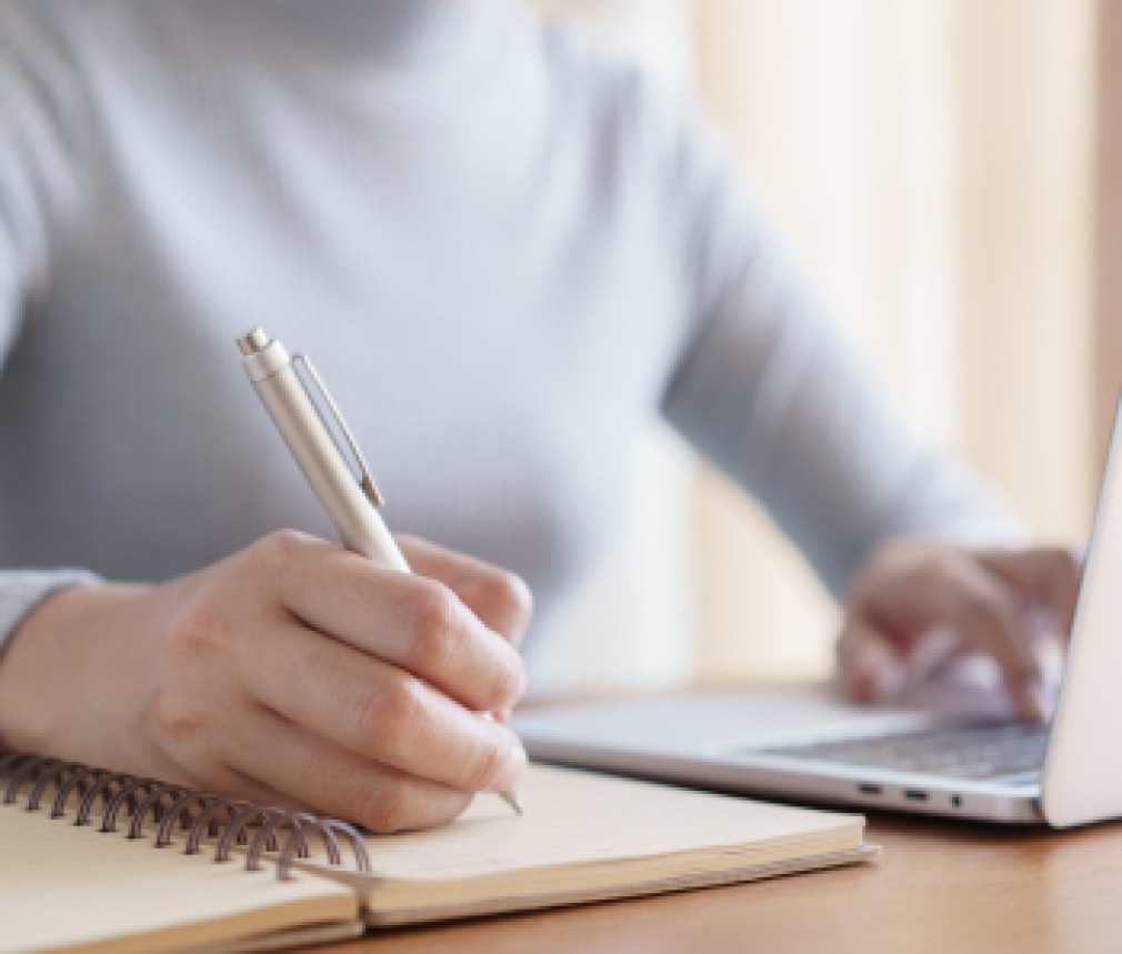 Hand of business women using laptop and write notebook while sitting working on the desk in the office