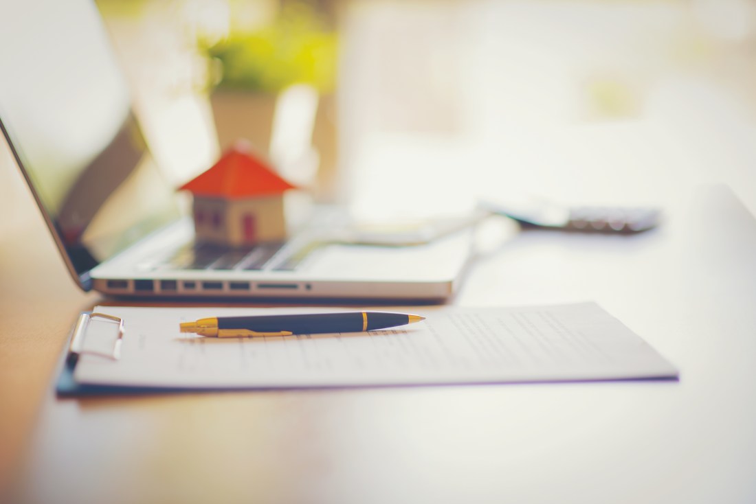 A scale house on some forms for a deed to conceptualize on the financial investment.