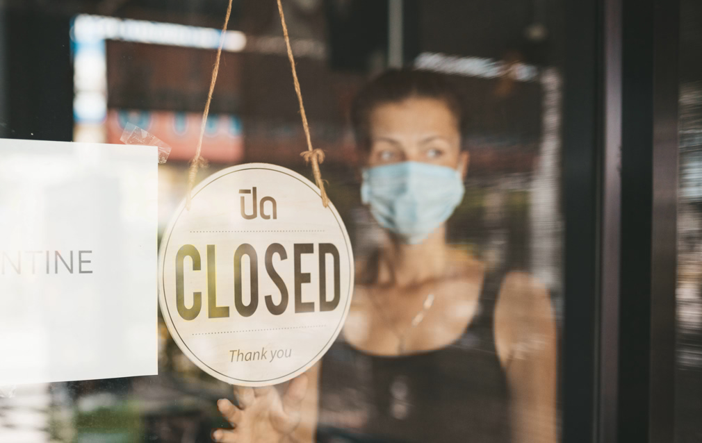 Store Owner in medical mask closed restaurant for quarantine