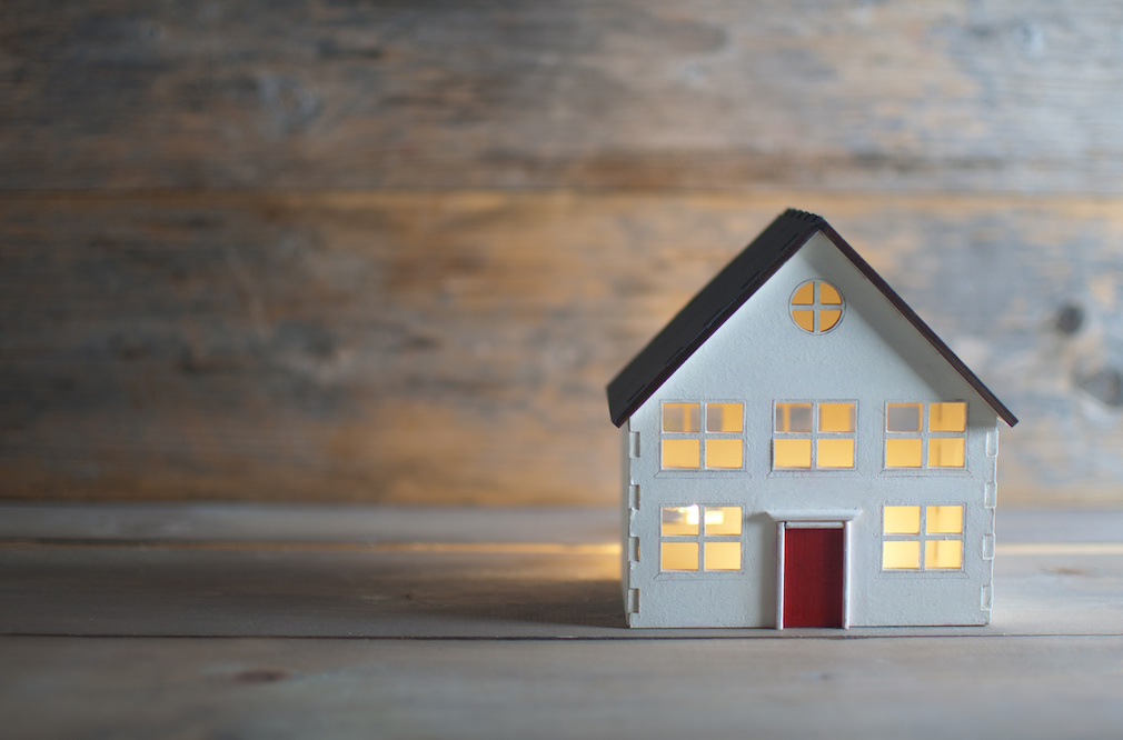 Miniature house over a wooden background