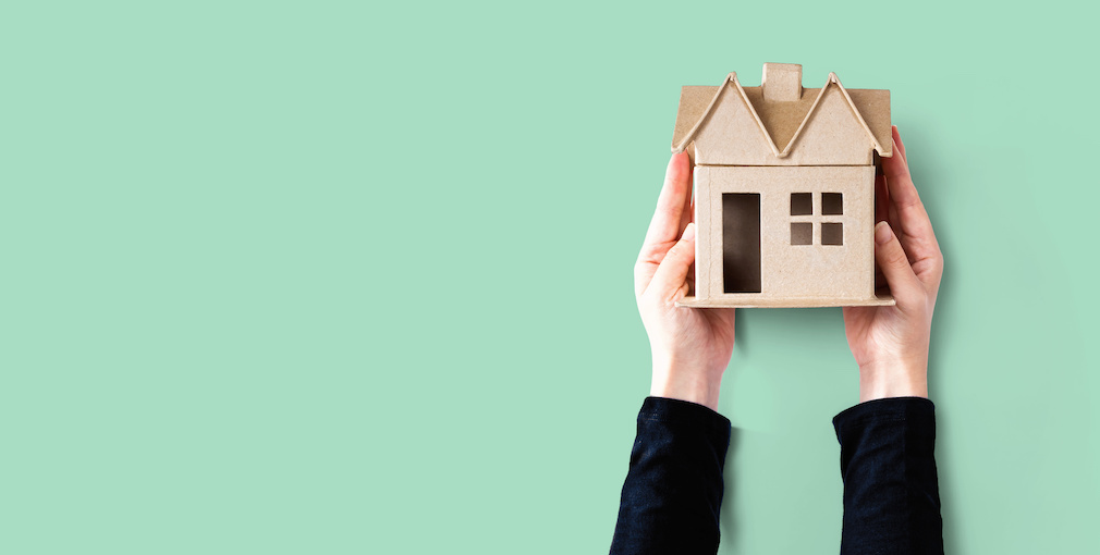 Woman holding a cardboard house