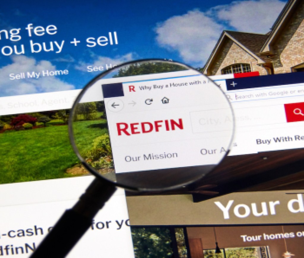 Redfin logo on official site under magnifying glass.