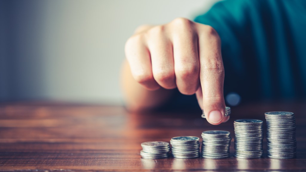 Hand putting money coin on each line rising - business saving money concept  for finance accounting