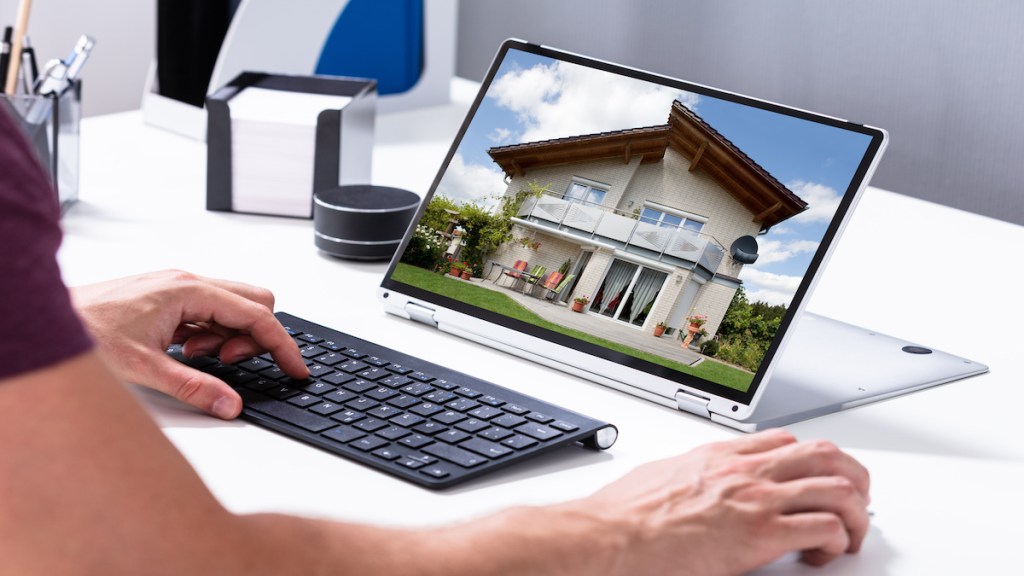 Man selecting new house on laptop at home