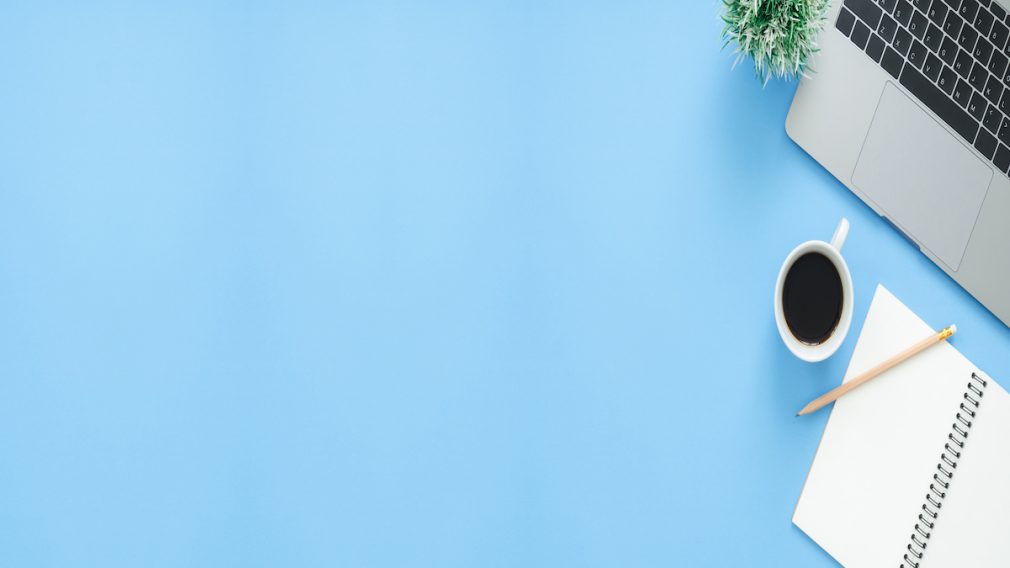 Minimal work space - Creative flat lay photo of workspace desk. Top view office desk with laptop, notebooks and coffee cup on blue color background. Panoramic banner background with copy space.