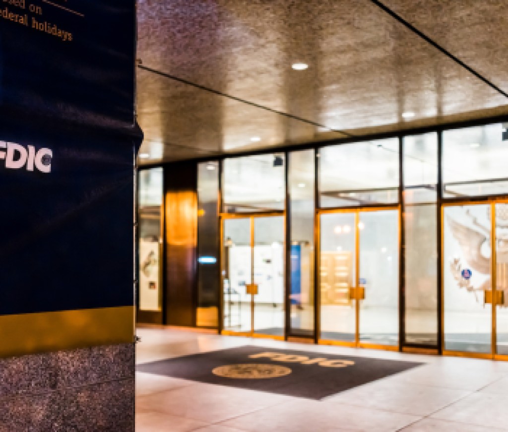 Washington DC, USA - December 28, 2017: FDIC United States Federal Deposit Insurance Corporation sign on wall of building with logo on 17th street in evening night, entrance doors