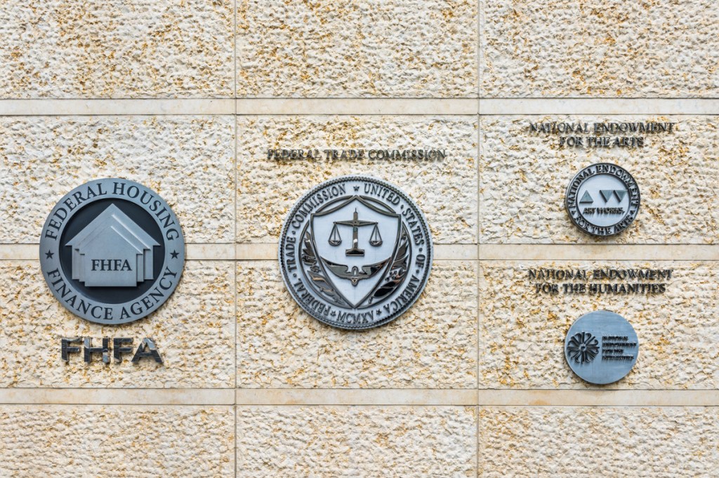 Federal Trade Commission and Housing Finance Agency seals in downtown with closeup of sign and logo