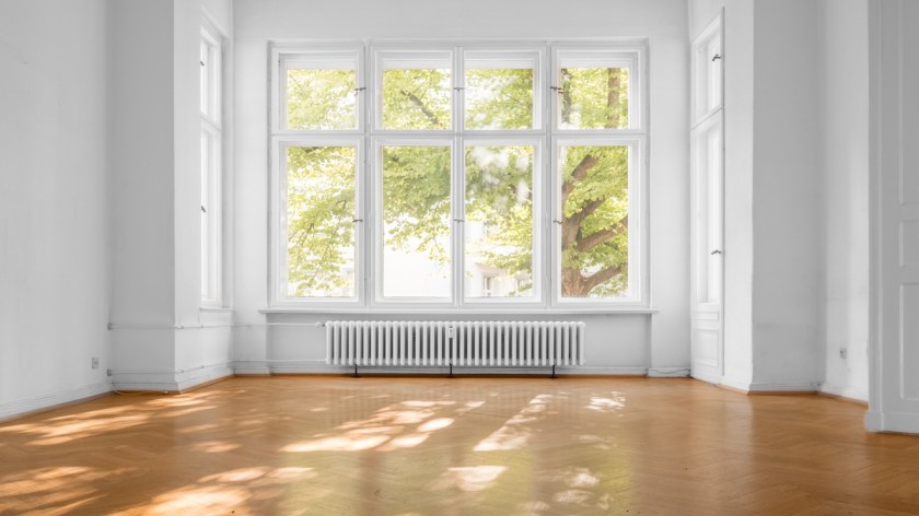 empty room in old apartment building with  parquet floor and big wooden windows