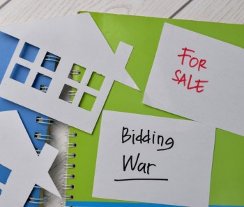 Bidding War and House For Sale write on sticky notes isolated on Office Desk