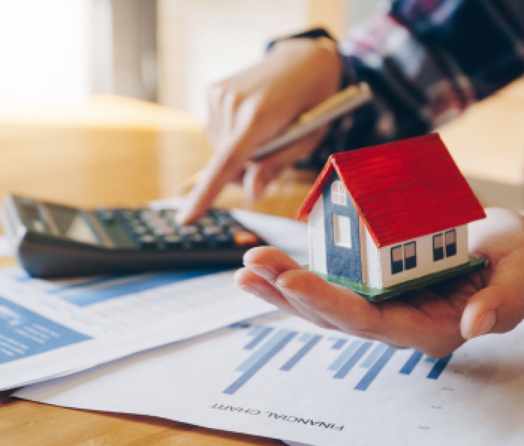 Woman holding house model in hand and calculating financial chart for investment to buying property.