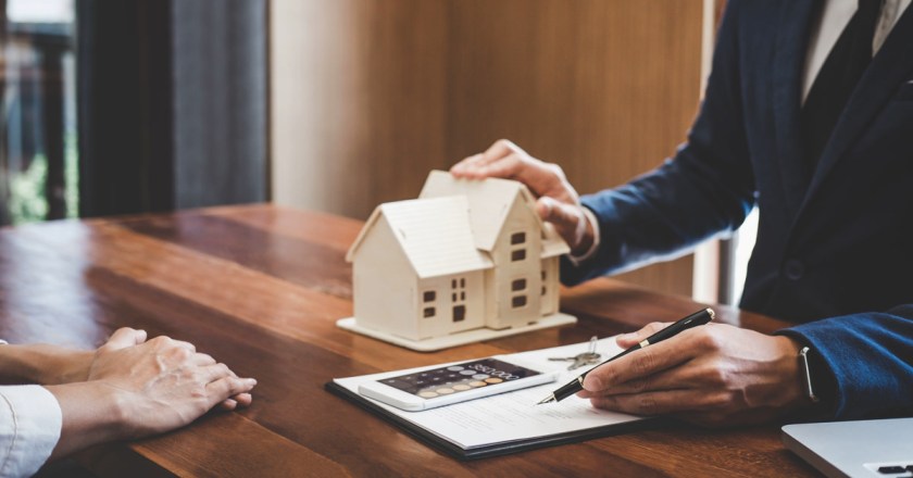 Real estate broker agent presenting and consult to customer to decision making sign insurance form agreement, home model, concerning mortgage loan offer for and house insurance