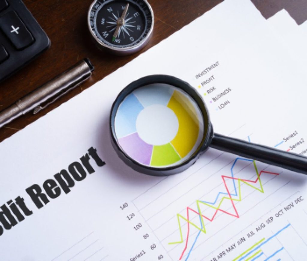 Magnifying glass on colourful pie chart with "Credit report" tex