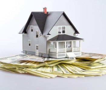 Model of a House on Money on Grey Background
