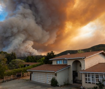 The California "River Fire" of Salinas,  in Monterey County, was ignited by dry lightning on August 16, 2020, fills the sky with dark smoke and flames as it burns close to a houses on its first day.