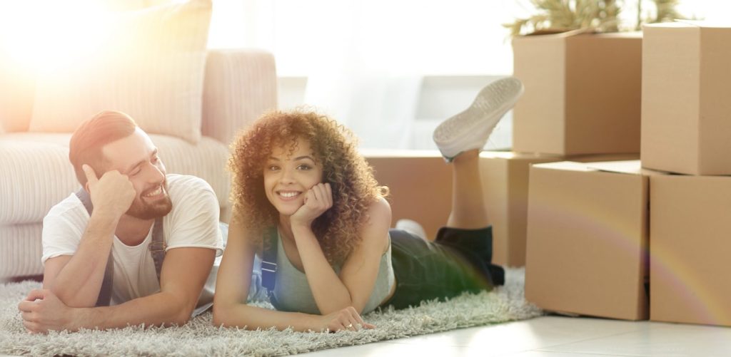 concept of moving to a new home. Happy couple lying on the floor