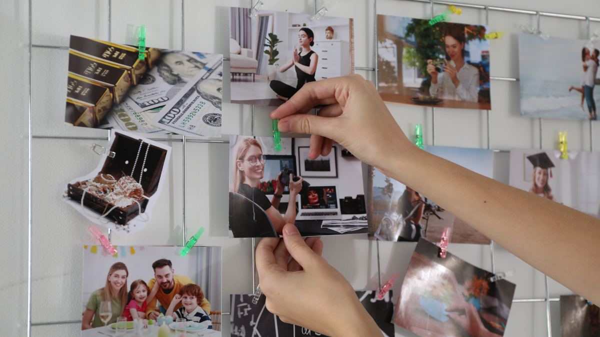 Person adding pictures to a vision board during vision board session.