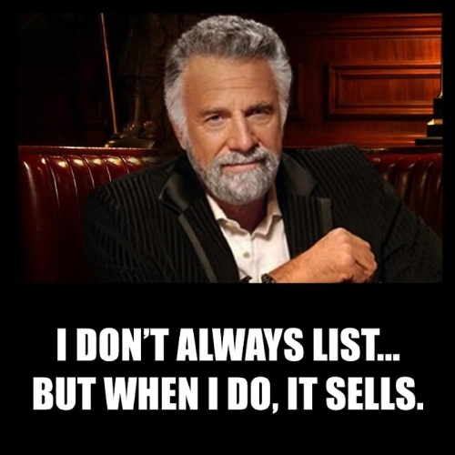 Older gentleman with gray hair and beard in black suit with a white shirt sitting at a booth.