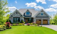 Highly detailed, bright, and clear photograph of a beautiful suburban home with a large front yard and a perfectly manicured lawn in the springtime.